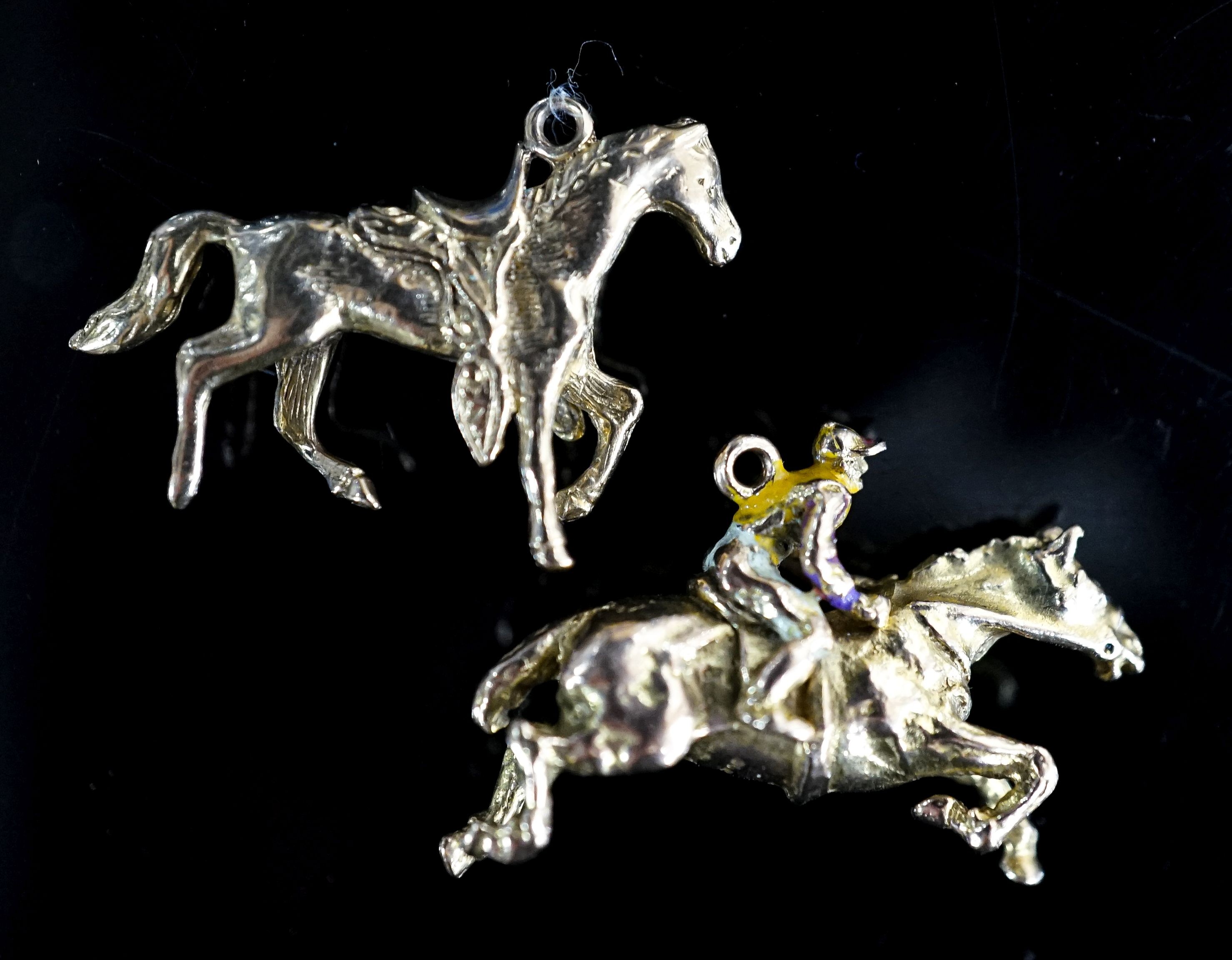 Two 9ct gold horse pendant charms including enamelled horse and jockey(a.f.), 33mm, gross 14.7 grams.